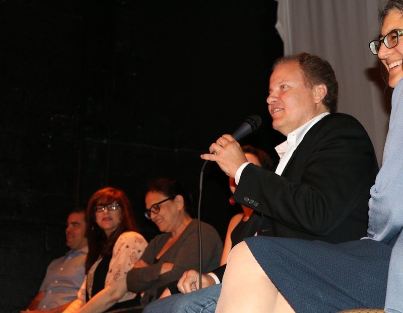 Maurice coaching a speaker, microphone in hand